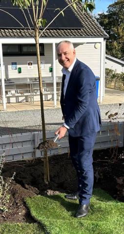 Richard Lochhead MP plants a cherry blossom tree to commemorate the park's top AA award